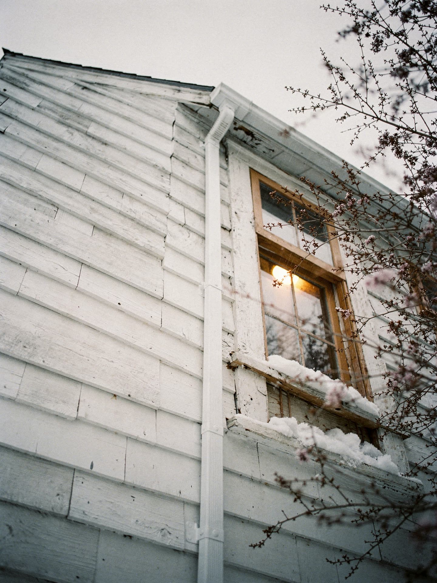 A ductless mini split head mounted high on a second floor bedroom wall.